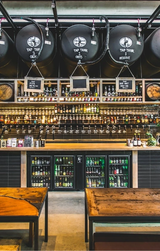 De bar met taptanks, flessenkoelkasten en rijen glazen