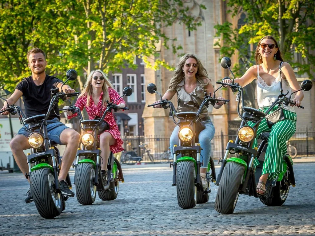 Vier mensen rijden op e-choppers over de kinderkopjes in de binnenstad