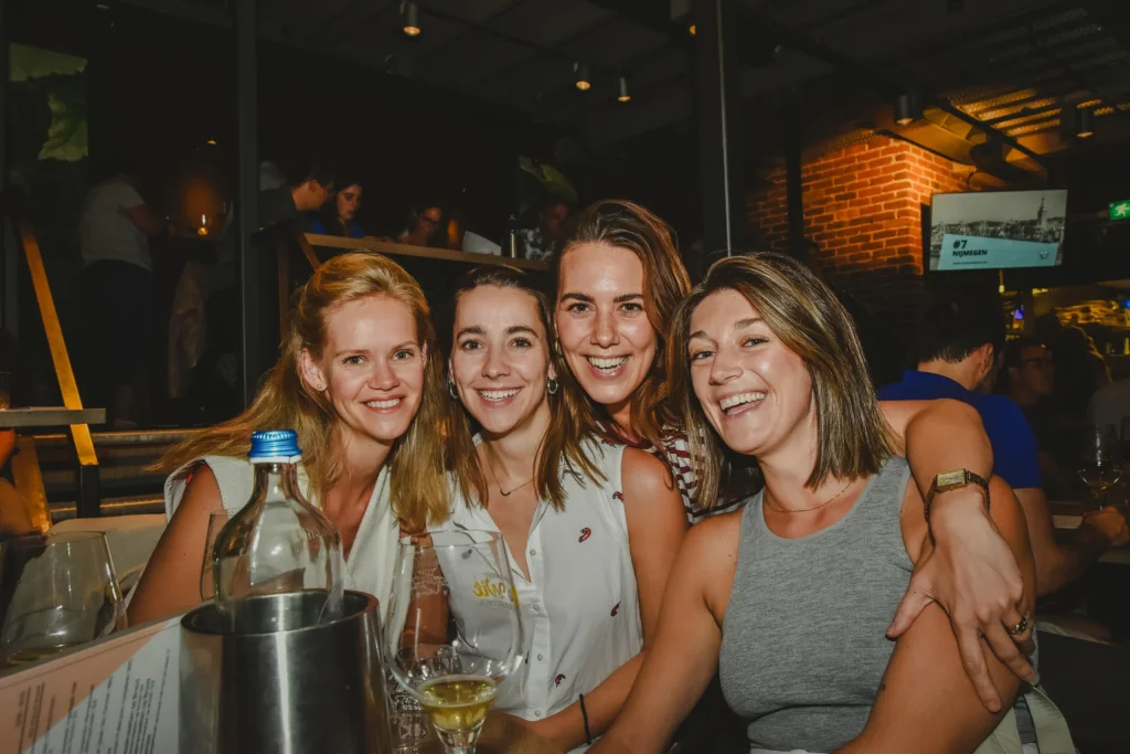 Vier vriendinnen samen aan tafel tijdens een avond in de brouwerij